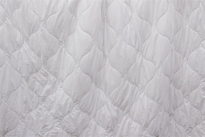 A white duvet and blanket airing out after cleaning